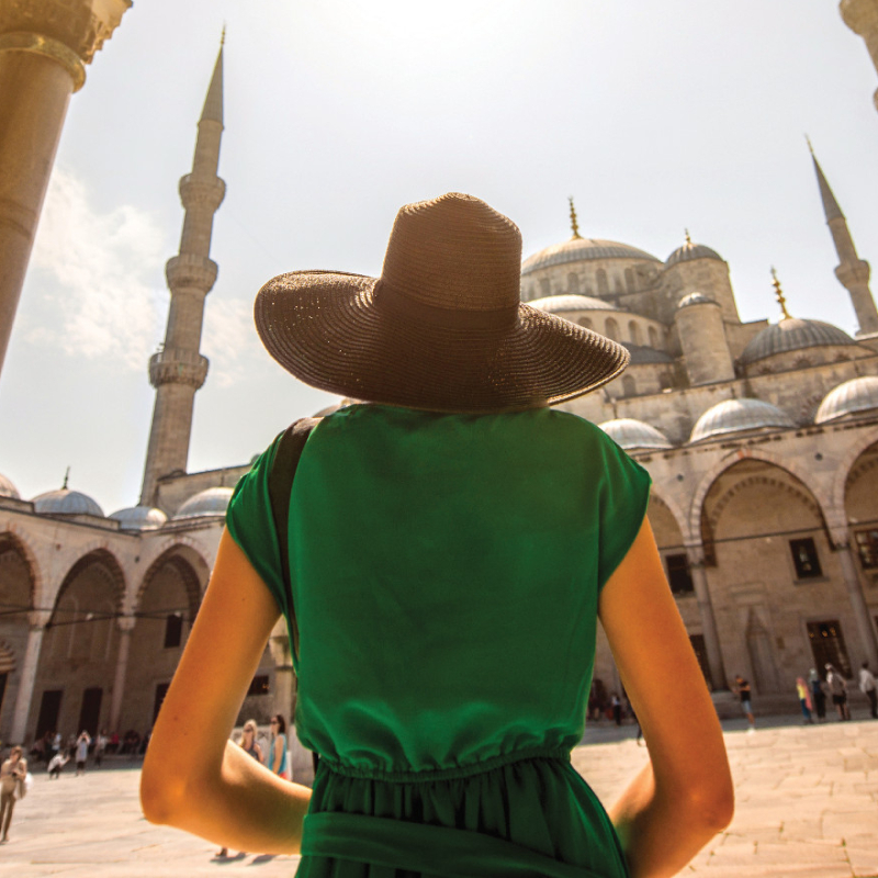 Žena v klobouku, která navštěvuje památky