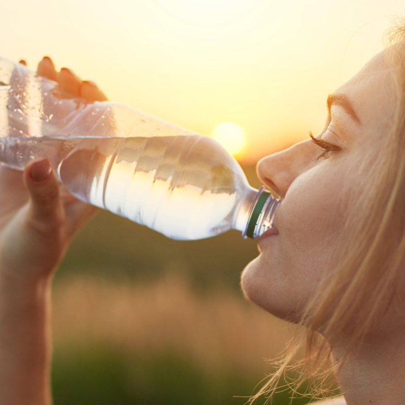 Mladá žena pijící vodu z plastové lahve