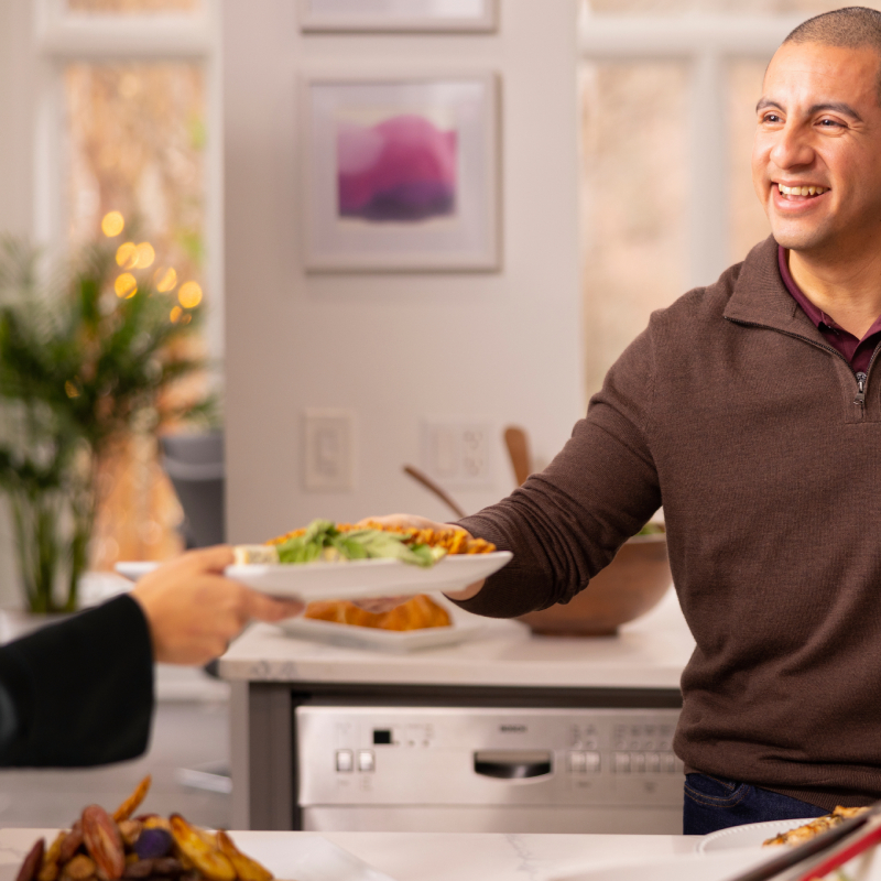 Muž podává talíř s jídlem